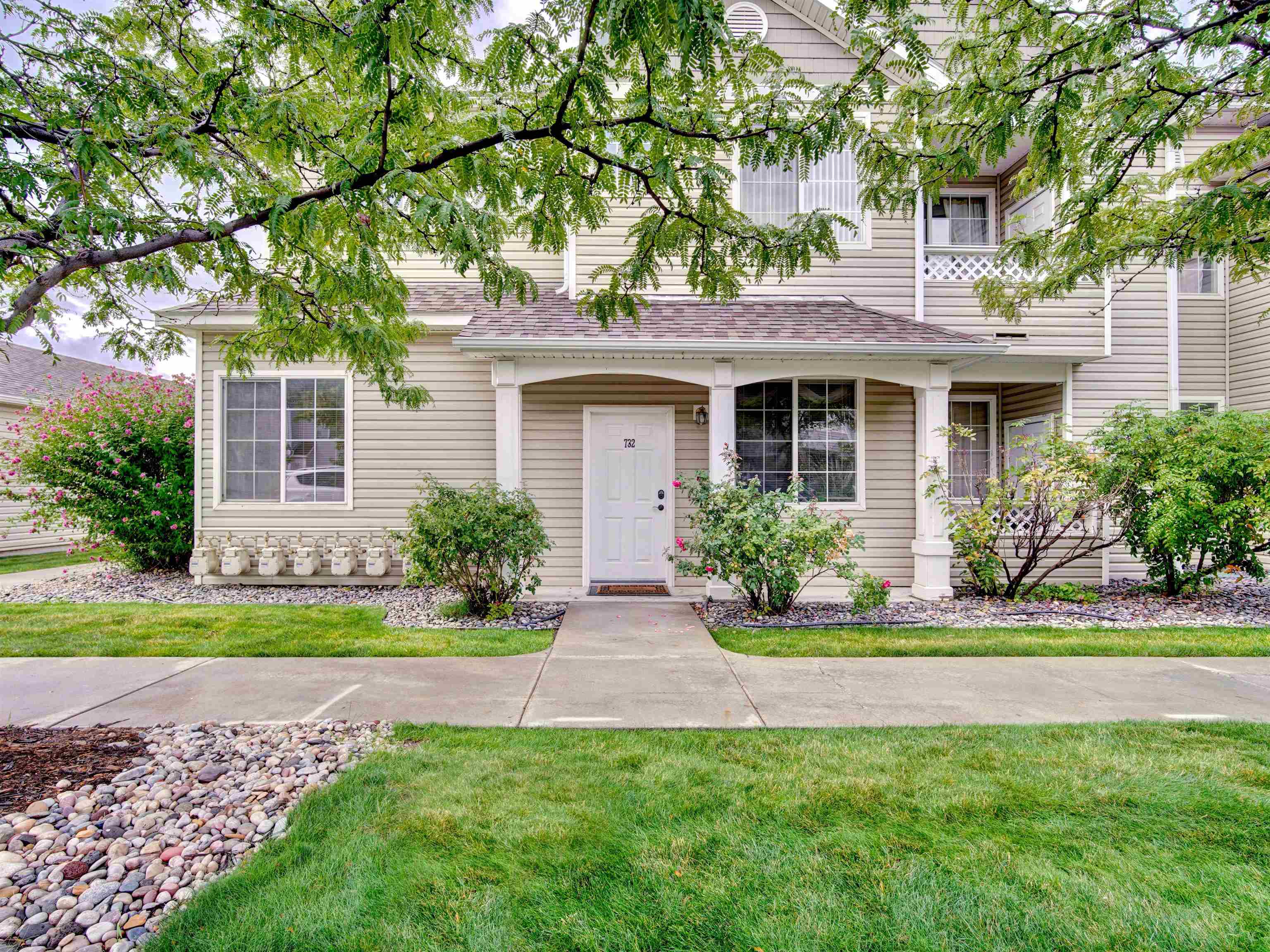 a front view of a house with yard and green space