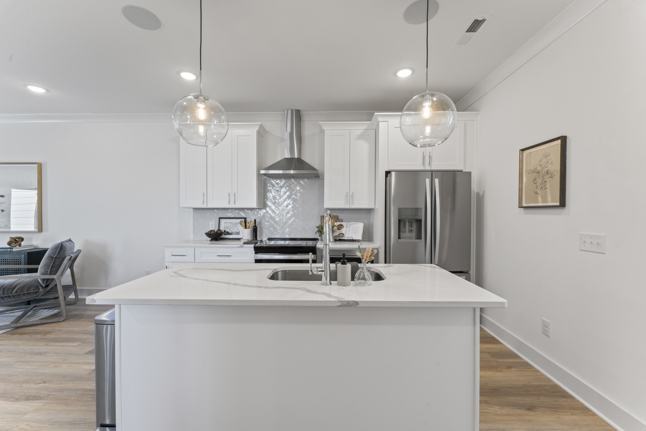 a kitchen with stainless steel appliances a table chairs and chandelier