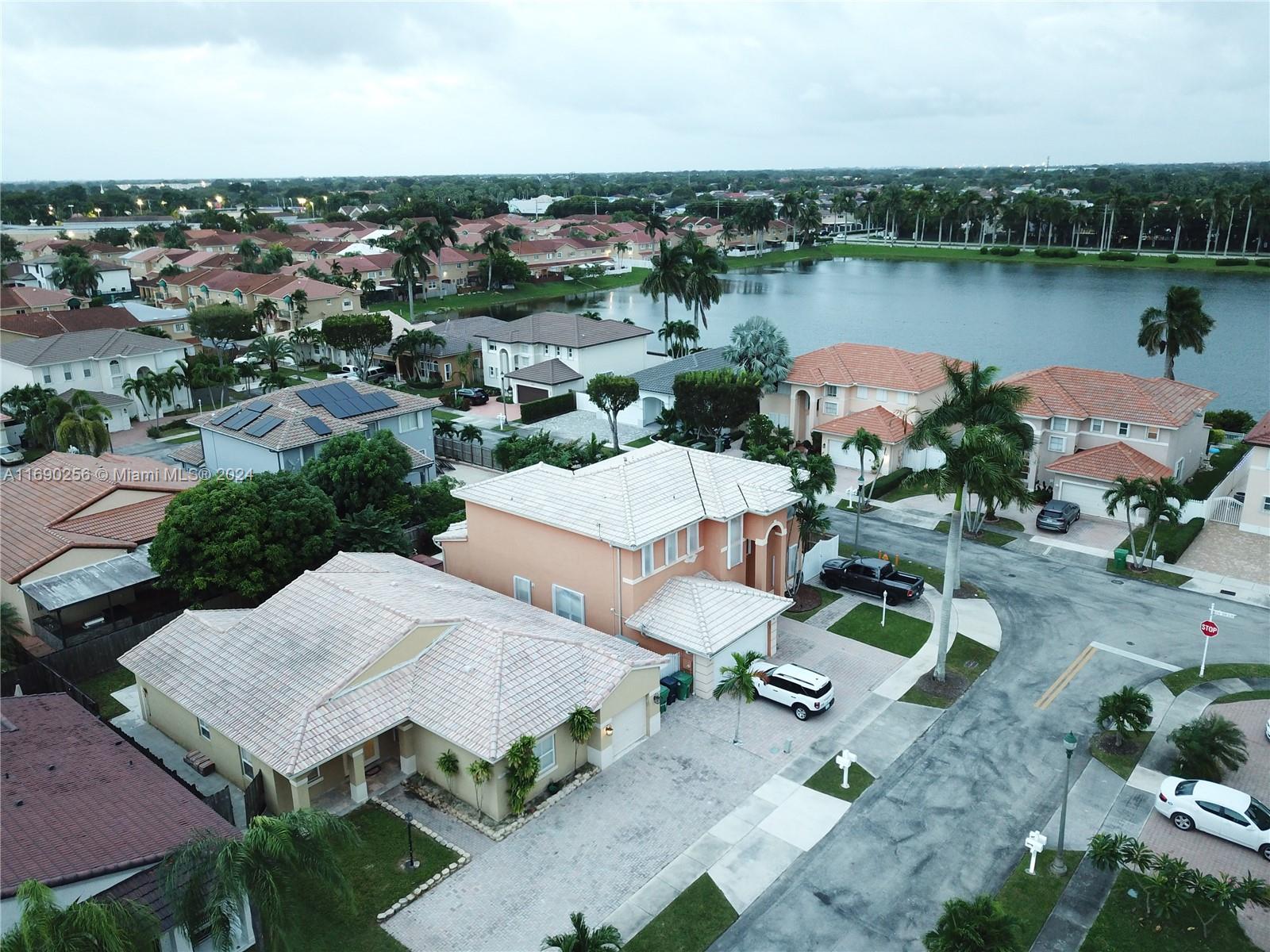 an aerial view of a house with outdoor space and lake view in back