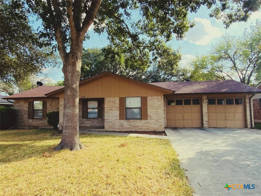 a front view of house with yard and trees in the background