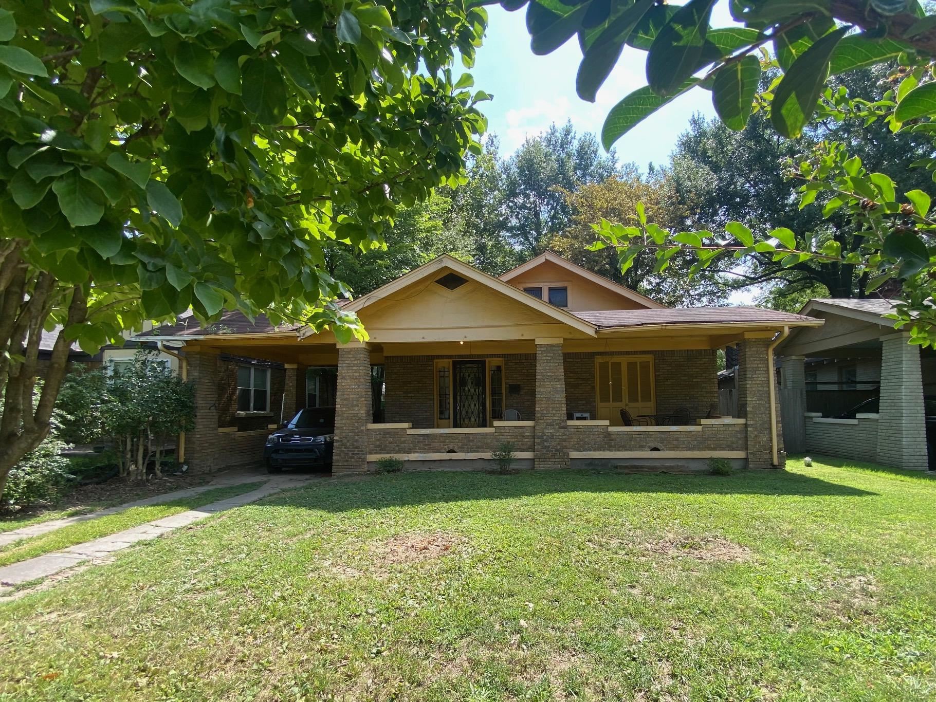 View of front of home with a carport and a front lawn