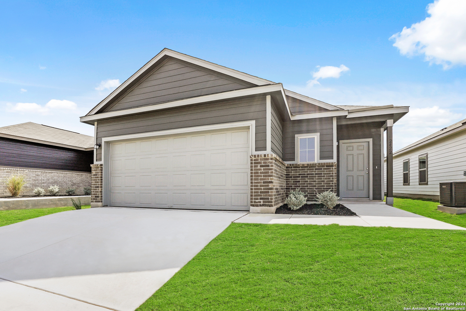 a front view of a house with a yard and garage