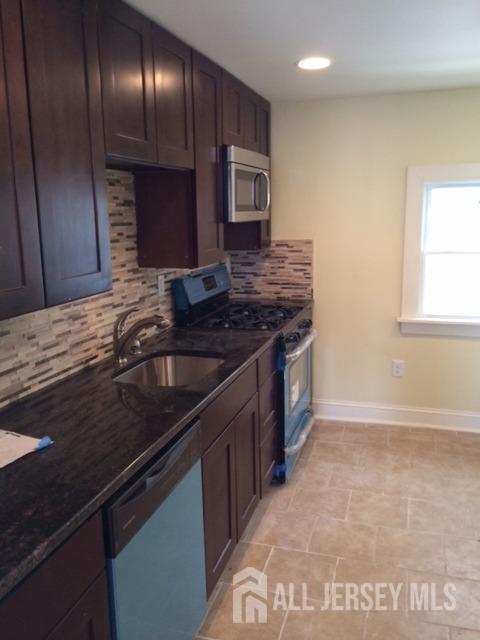 a kitchen with stainless steel appliances granite countertop a sink stove and cabinets