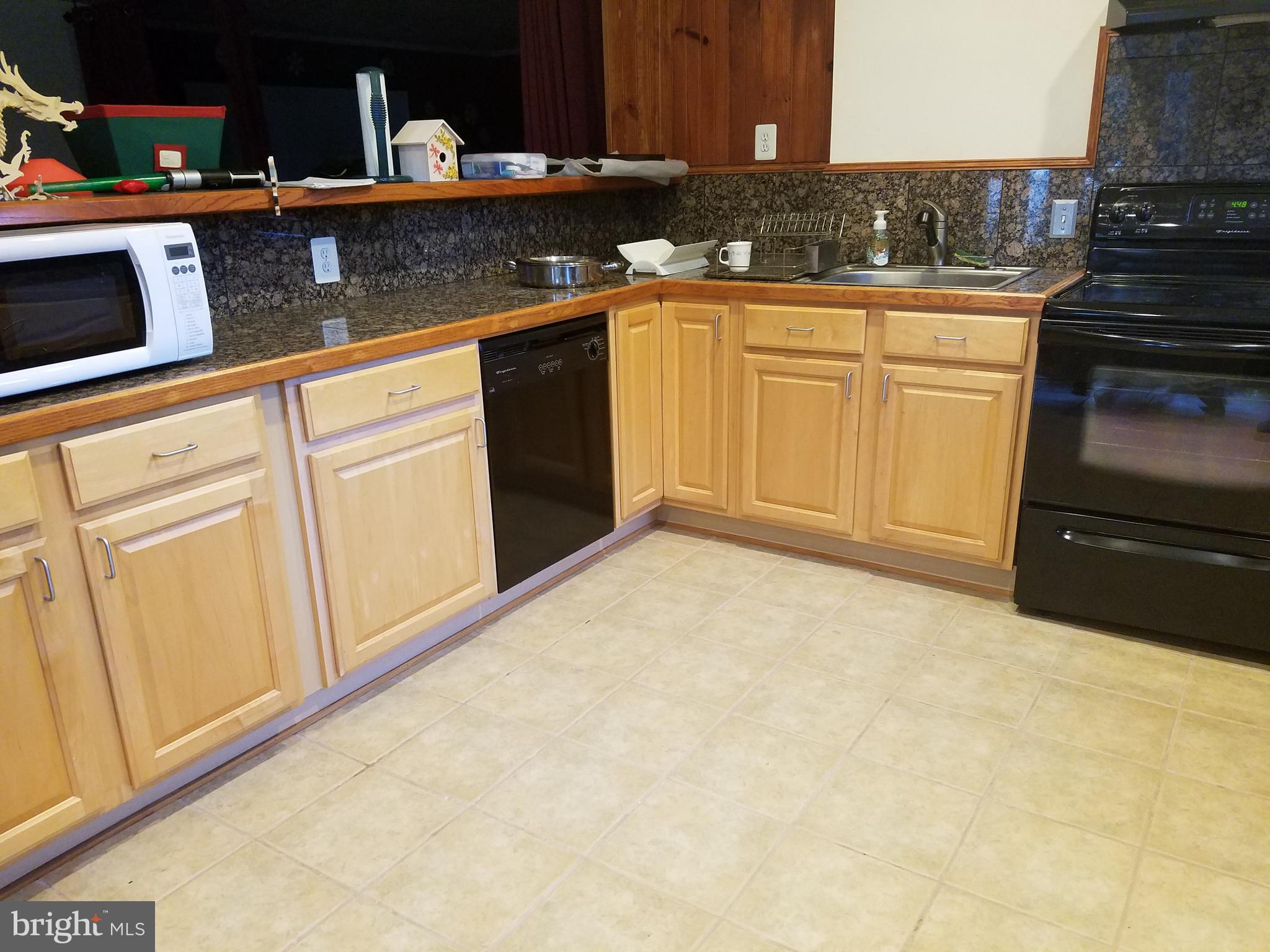 a kitchen with granite countertop a sink and cabinets