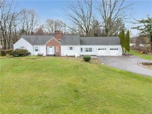 Ranch-style house with a front yard and a garage