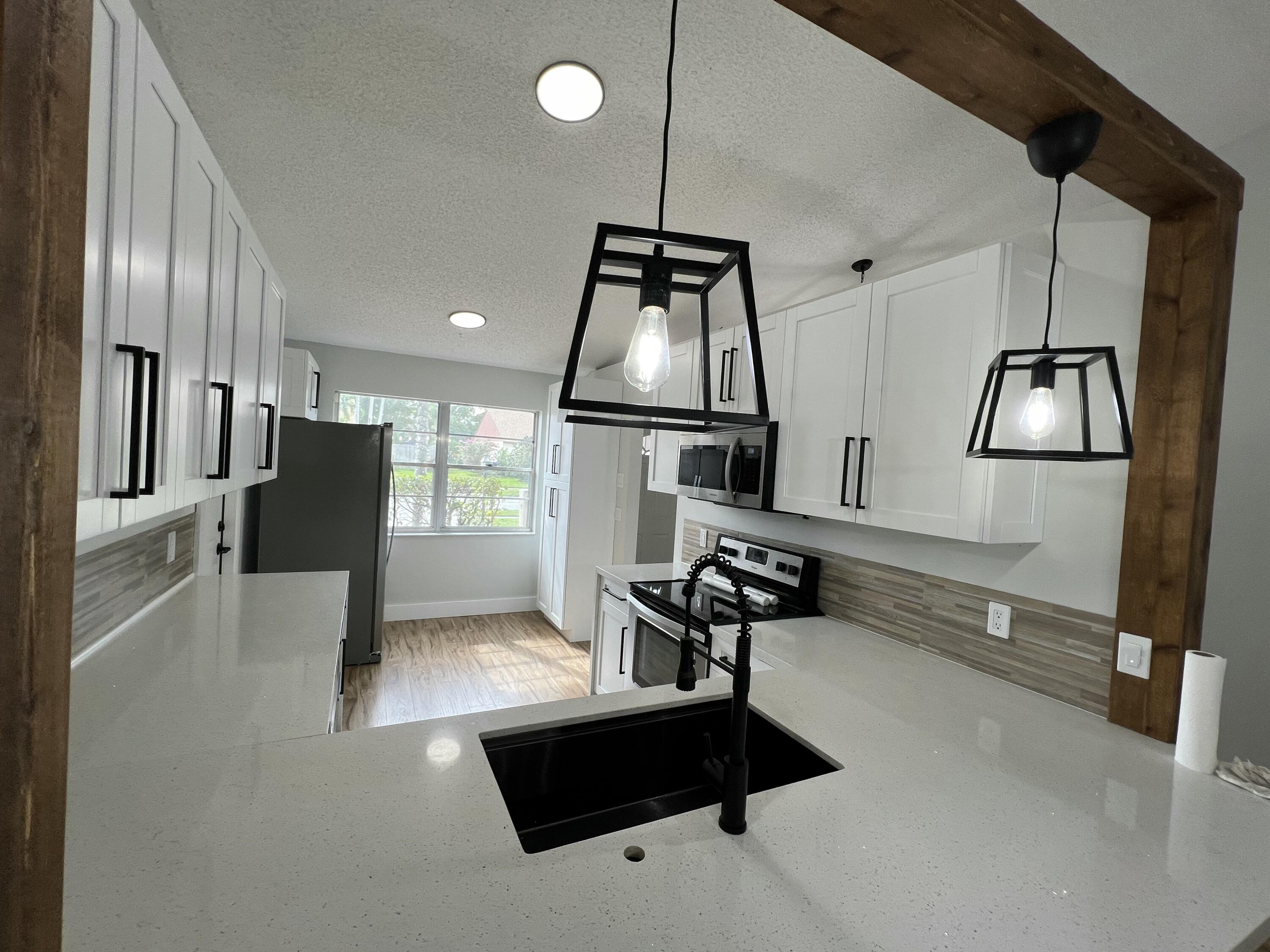 a kitchen with stainless steel appliances kitchen island hardwood floor sink and stove