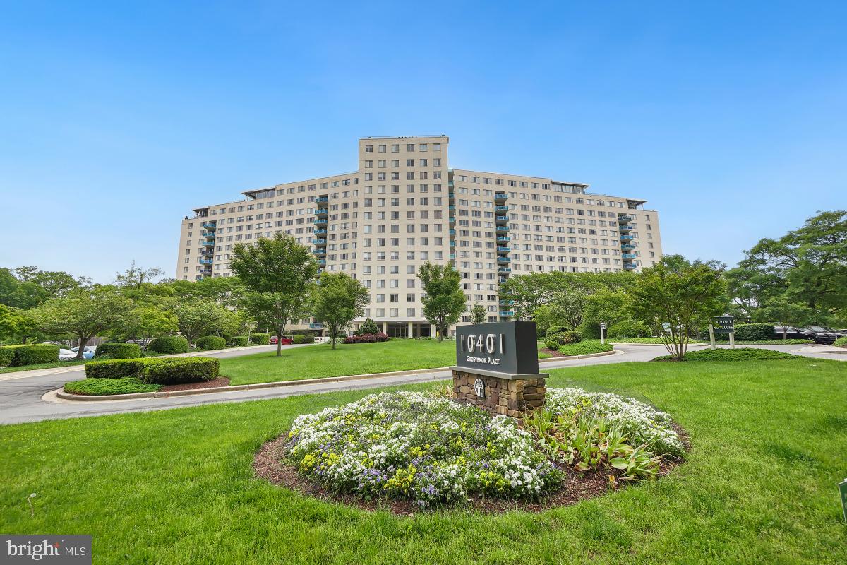 a view of a big building with a big yard and large trees