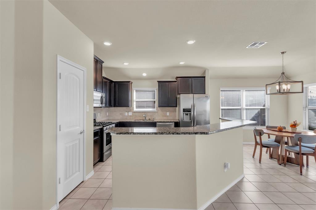 a kitchen with stainless steel appliances granite countertop a sink and a refrigerator