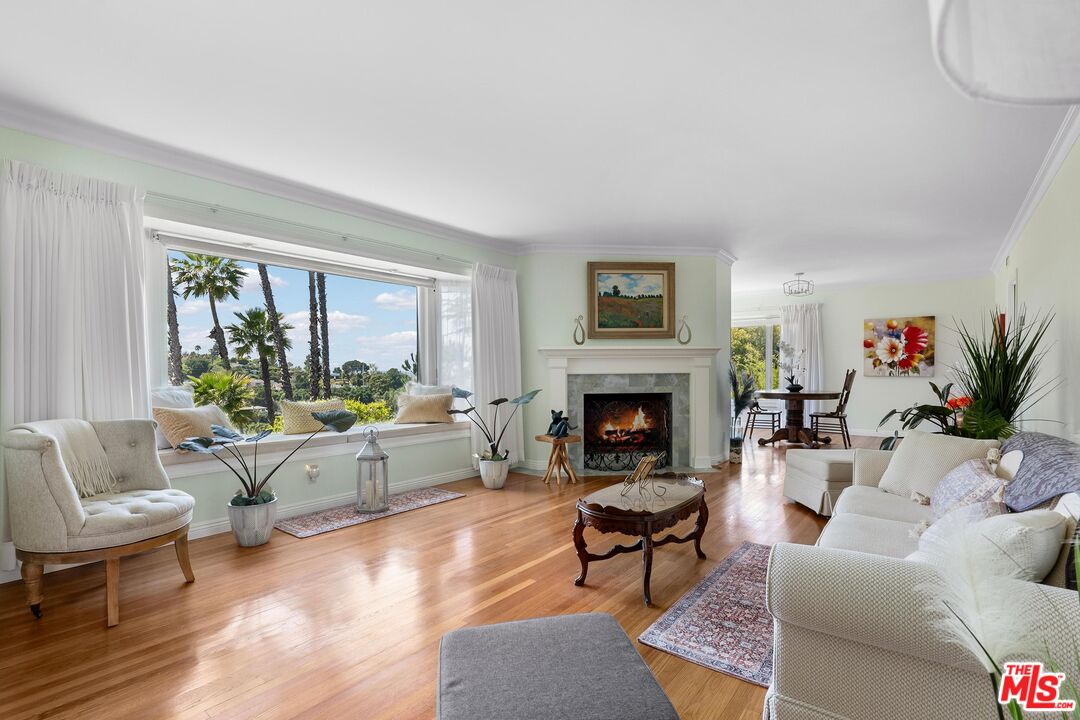 a living room with furniture fireplace and a large window