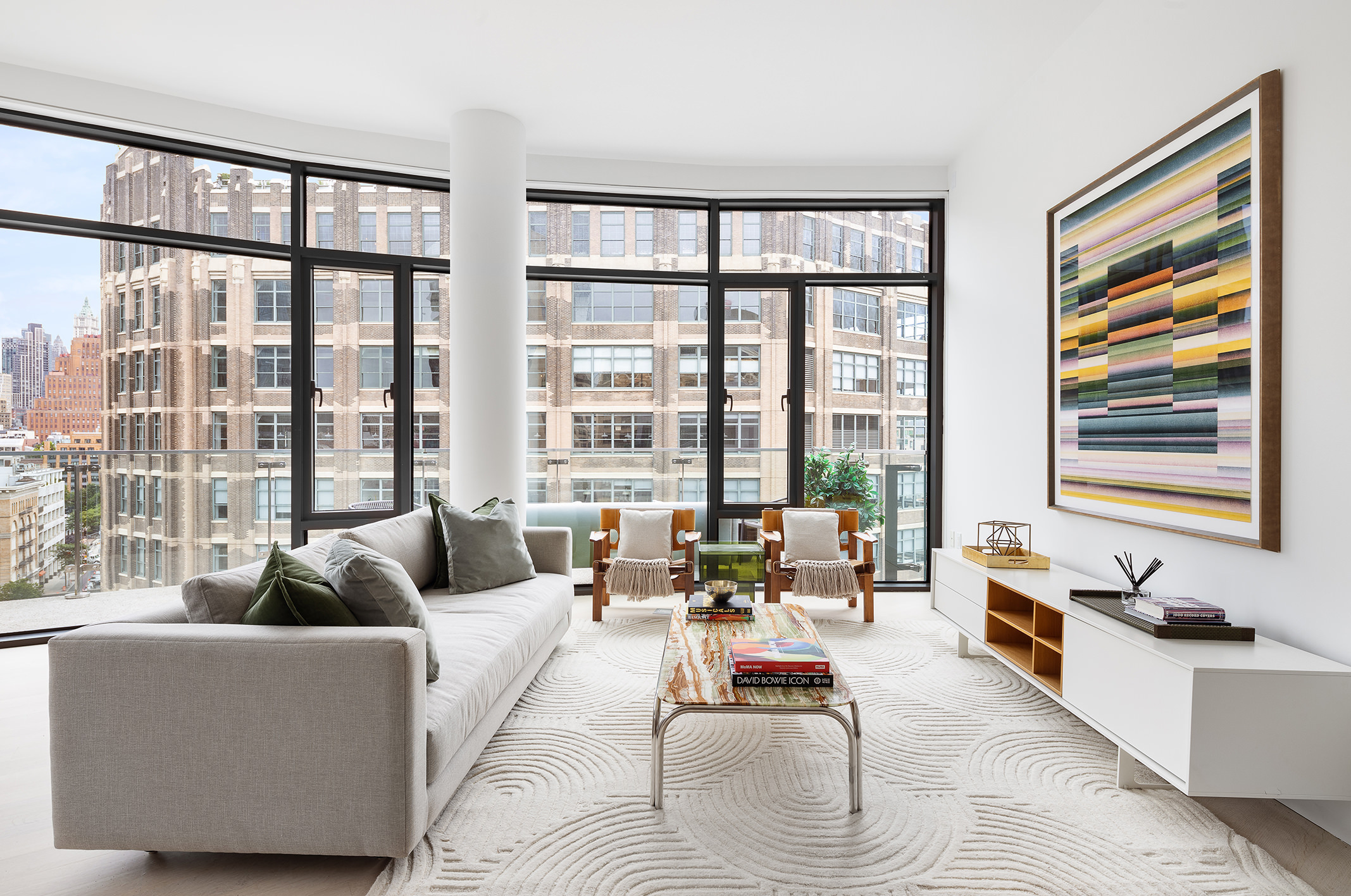 a living room with furniture and floor to ceiling windows