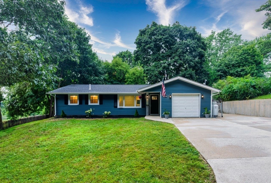 a front view of a house with a yard and trees