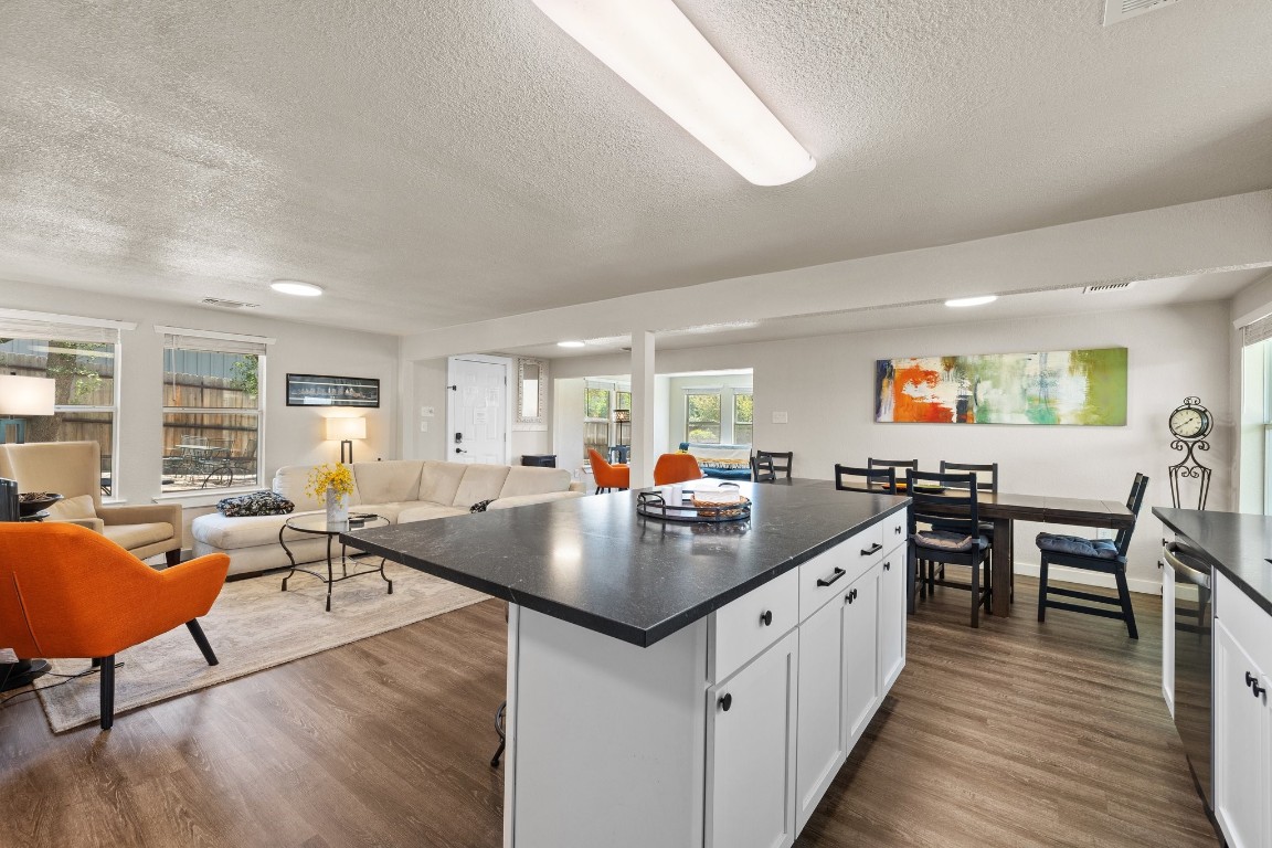 a open kitchen with stainless steel appliances granite countertop a table and chairs in it