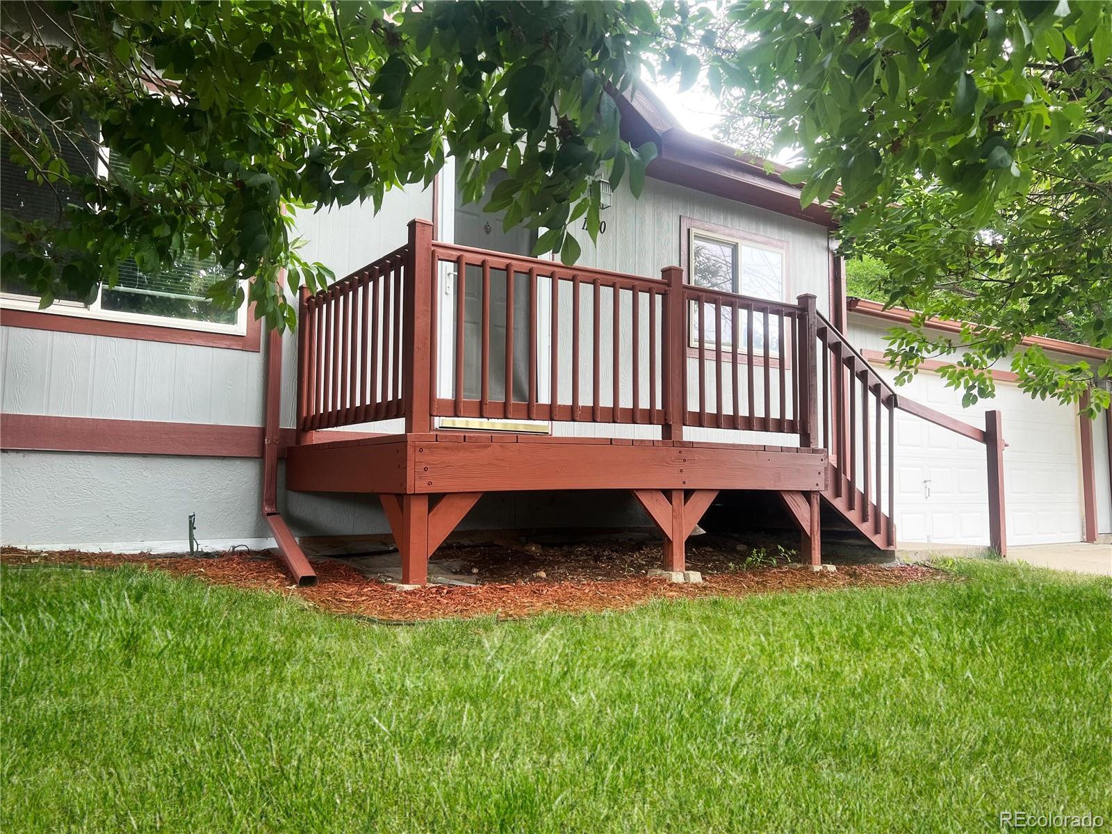 a view of a deck in front of house with a yard