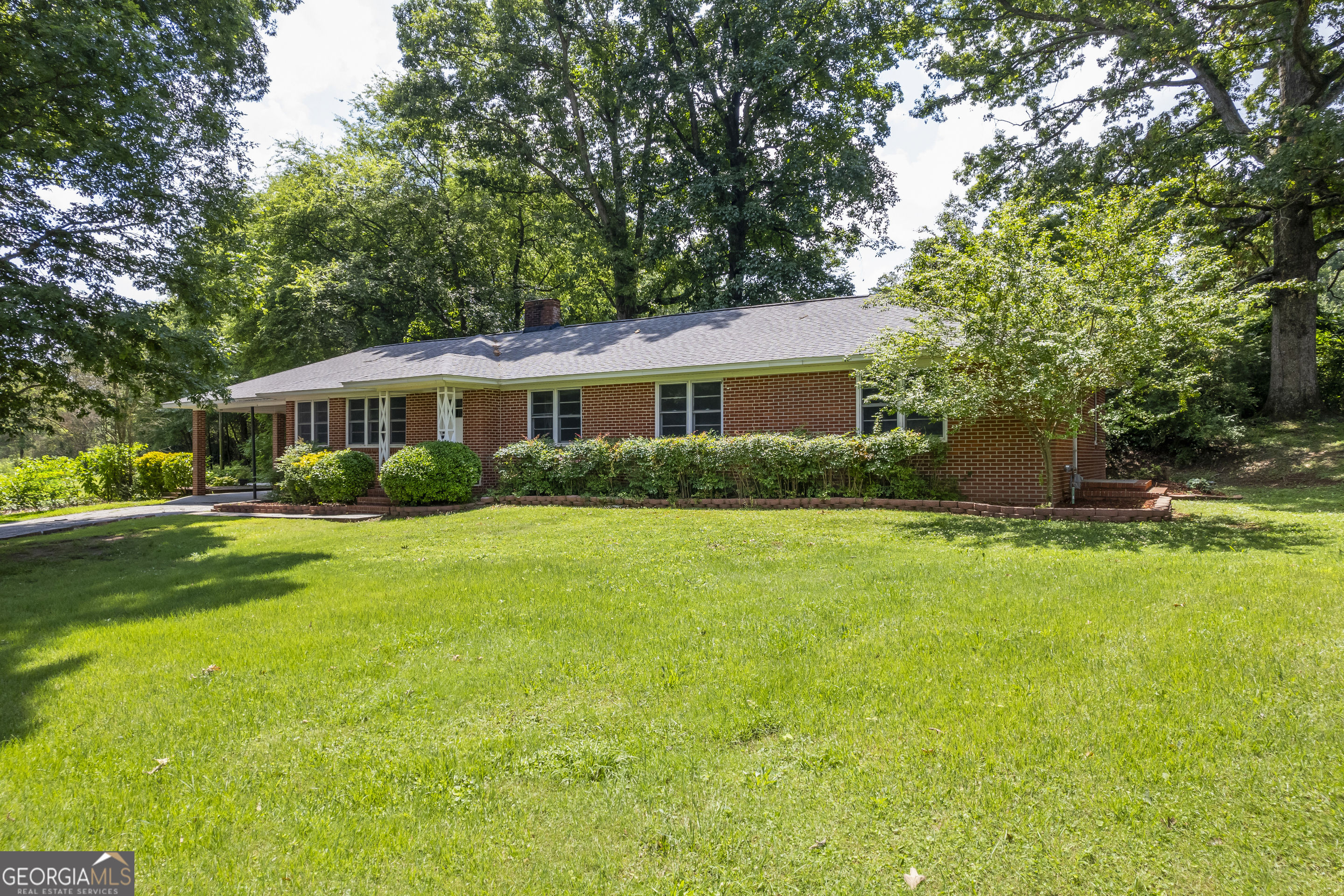 a front view of a house with a yard and green space