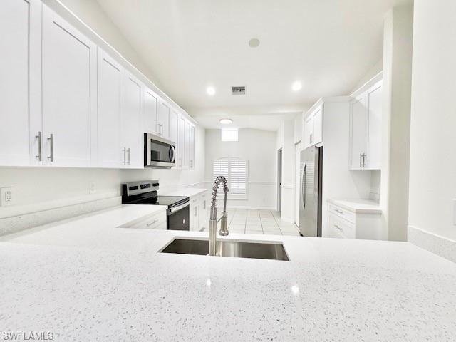 a large white kitchen with stainless steel appliances