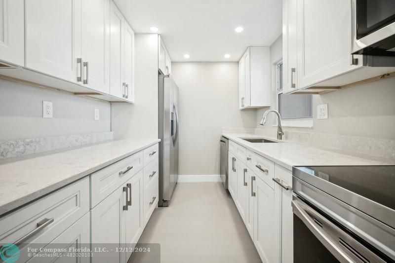 a kitchen with granite countertop white cabinets and white appliances