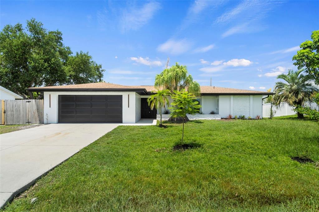 a front view of a house with a yard and a garage