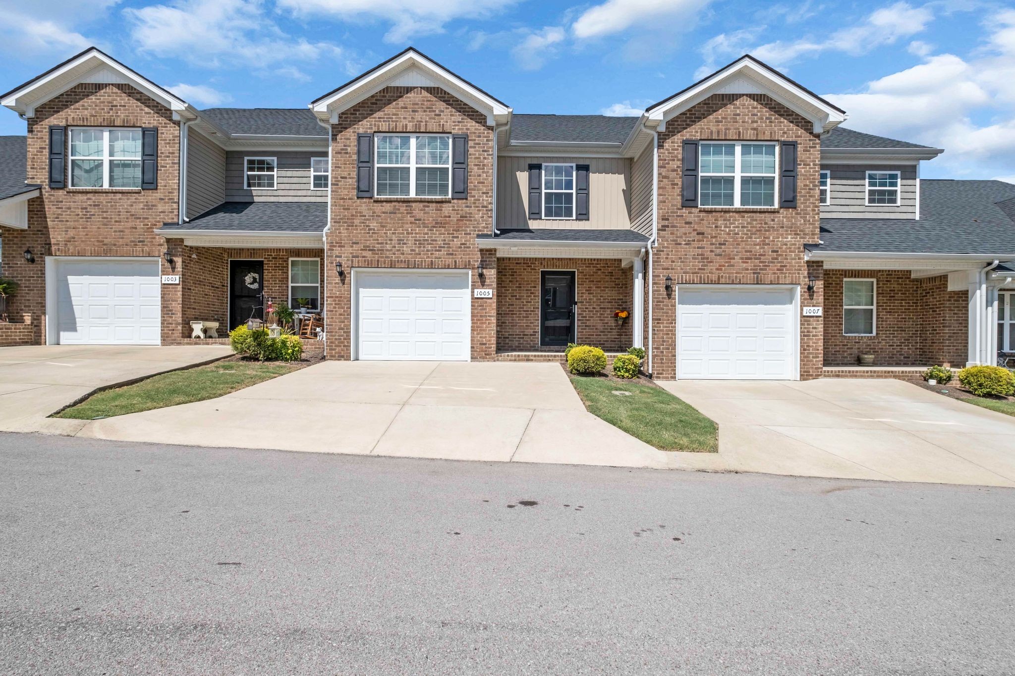 a front view of a house with yard and parking