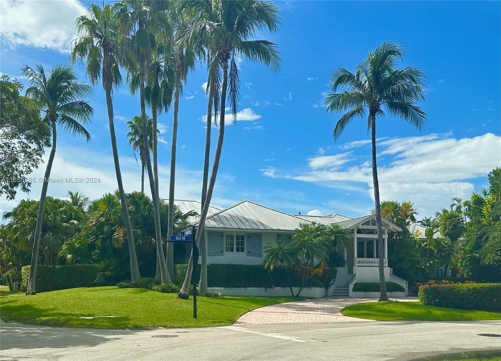 a palm tree sitting in front of a house with a yard