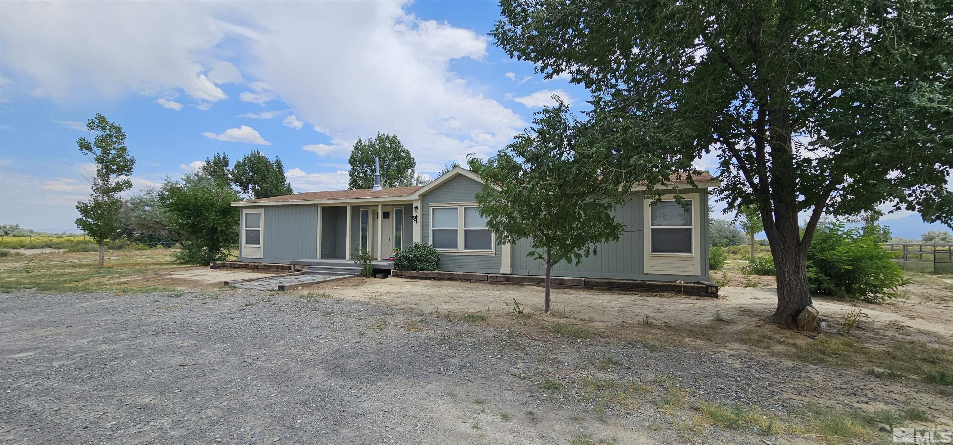 a view of a house with backyard and a tree