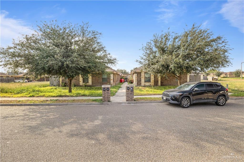 a view of a house with a big yard and a large tree