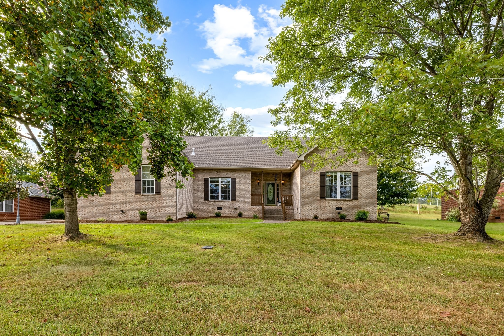 a front view of house with yard and trees around