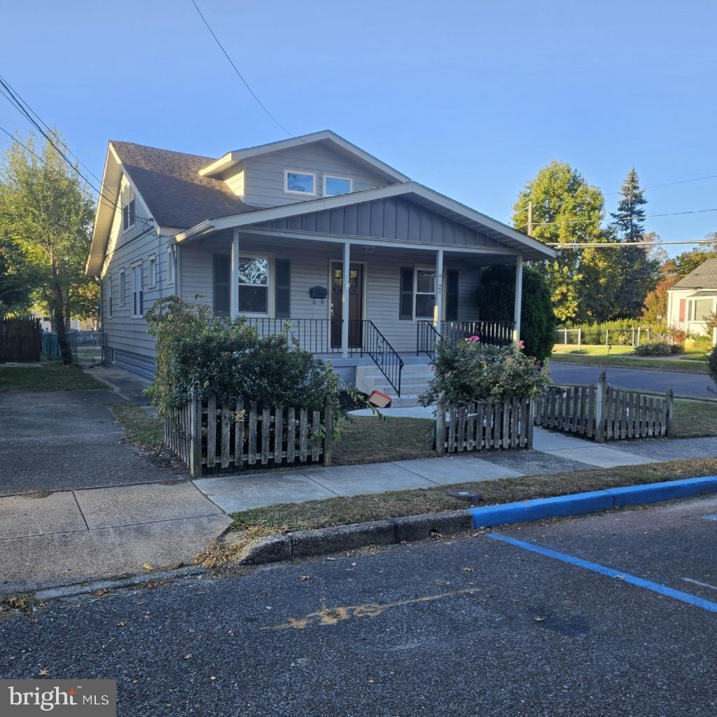 a front view of a house with a yard and potted plants