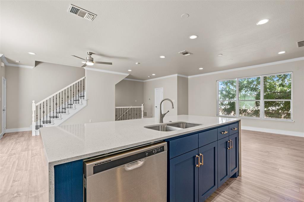 a kitchen with a sink appliances and a wooden floor