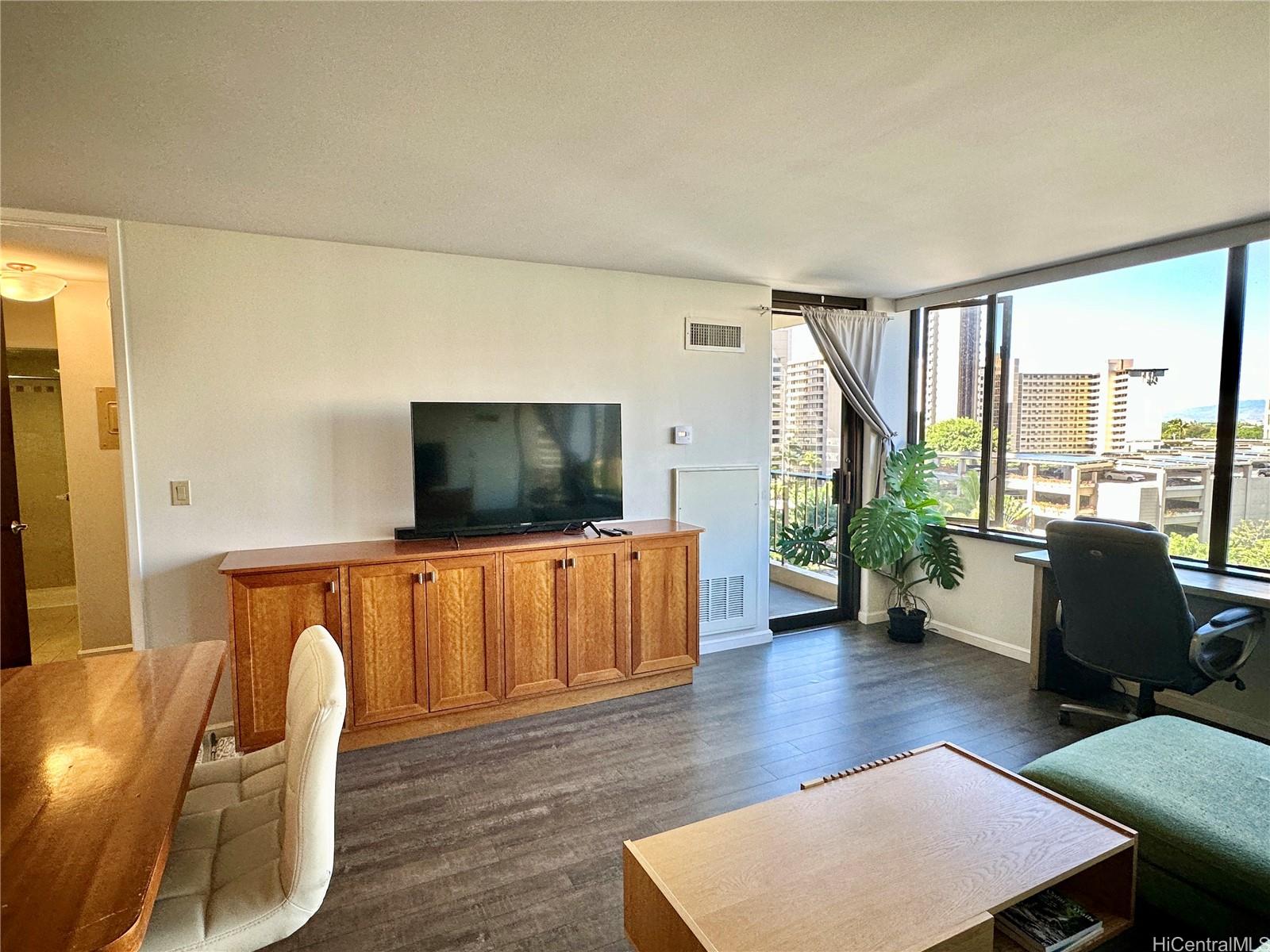 a living room with furniture a flat screen tv and a large window