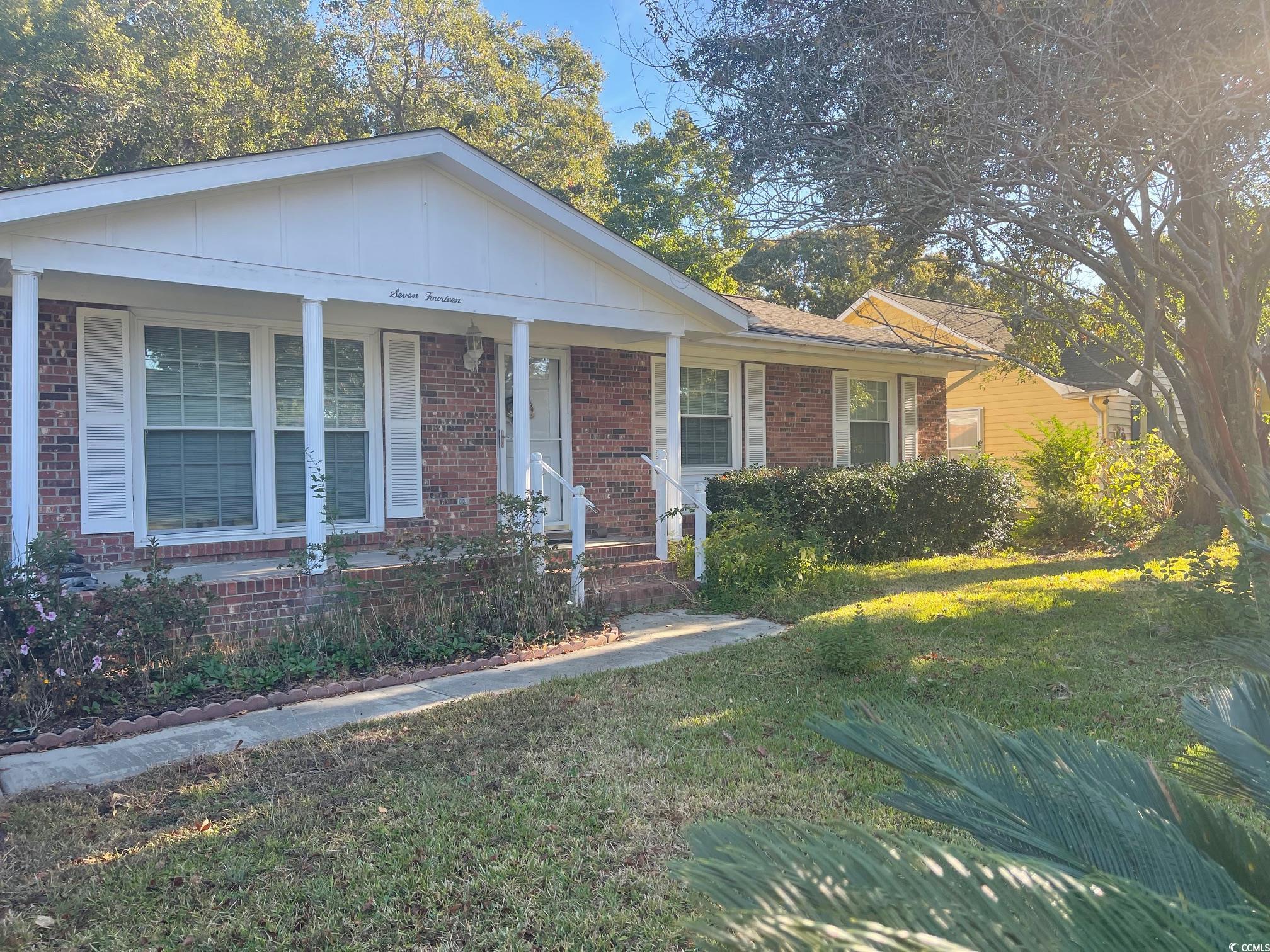 View of front facade featuring a front yard and a