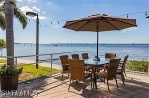 a view of a roof deck with table and chairs under an umbrella