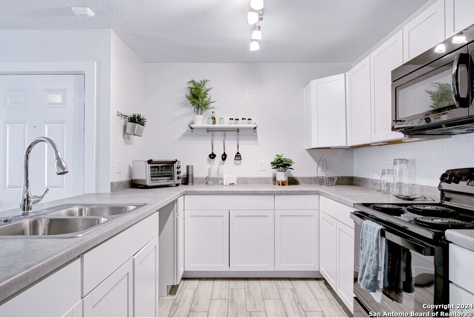 a kitchen with white cabinets stainless steel appliances and sink