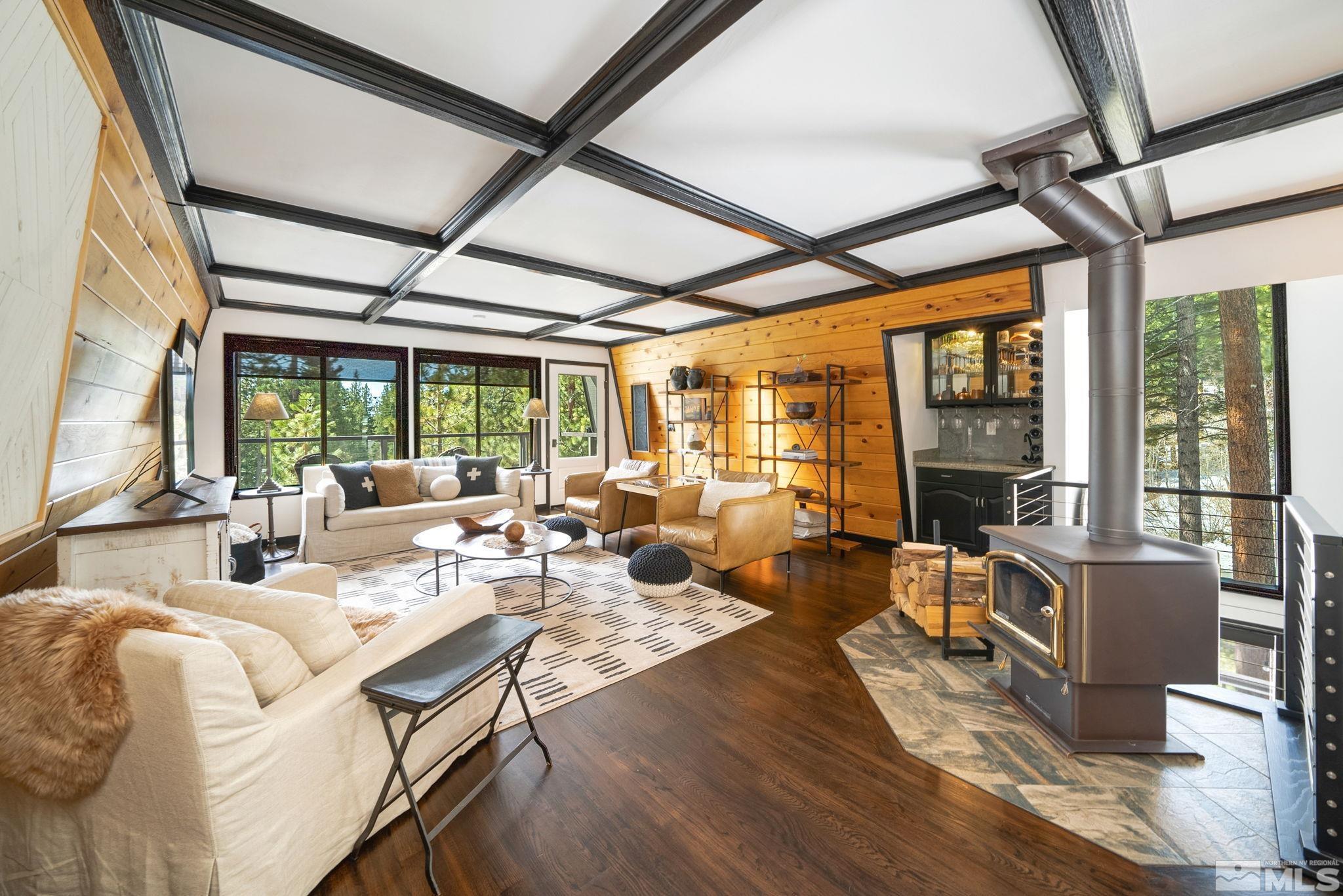 a living room with furniture large windows and wooden floor