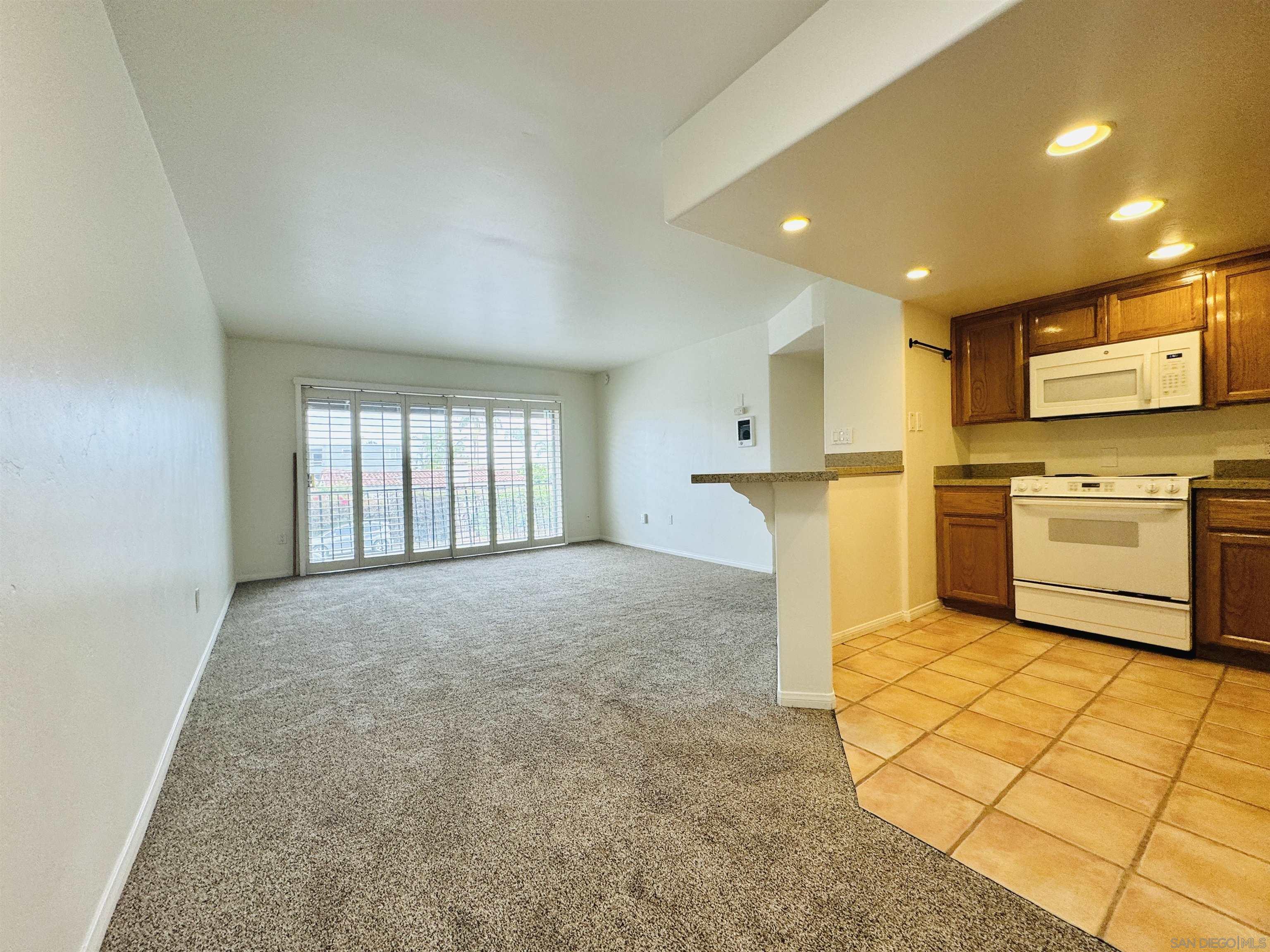 a view of a kitchen with furniture and a refrigerator