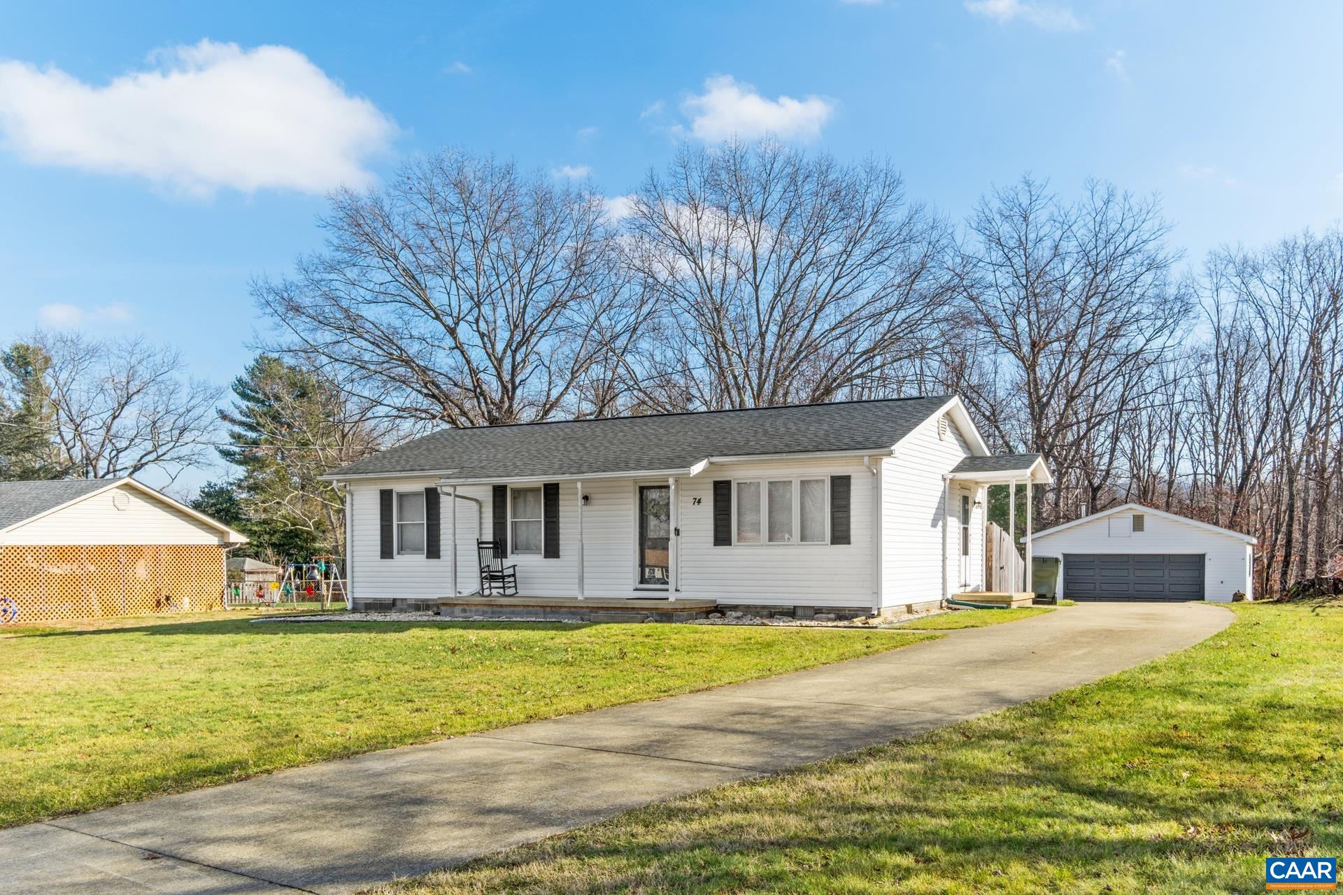 a front view of house with yard and trees around