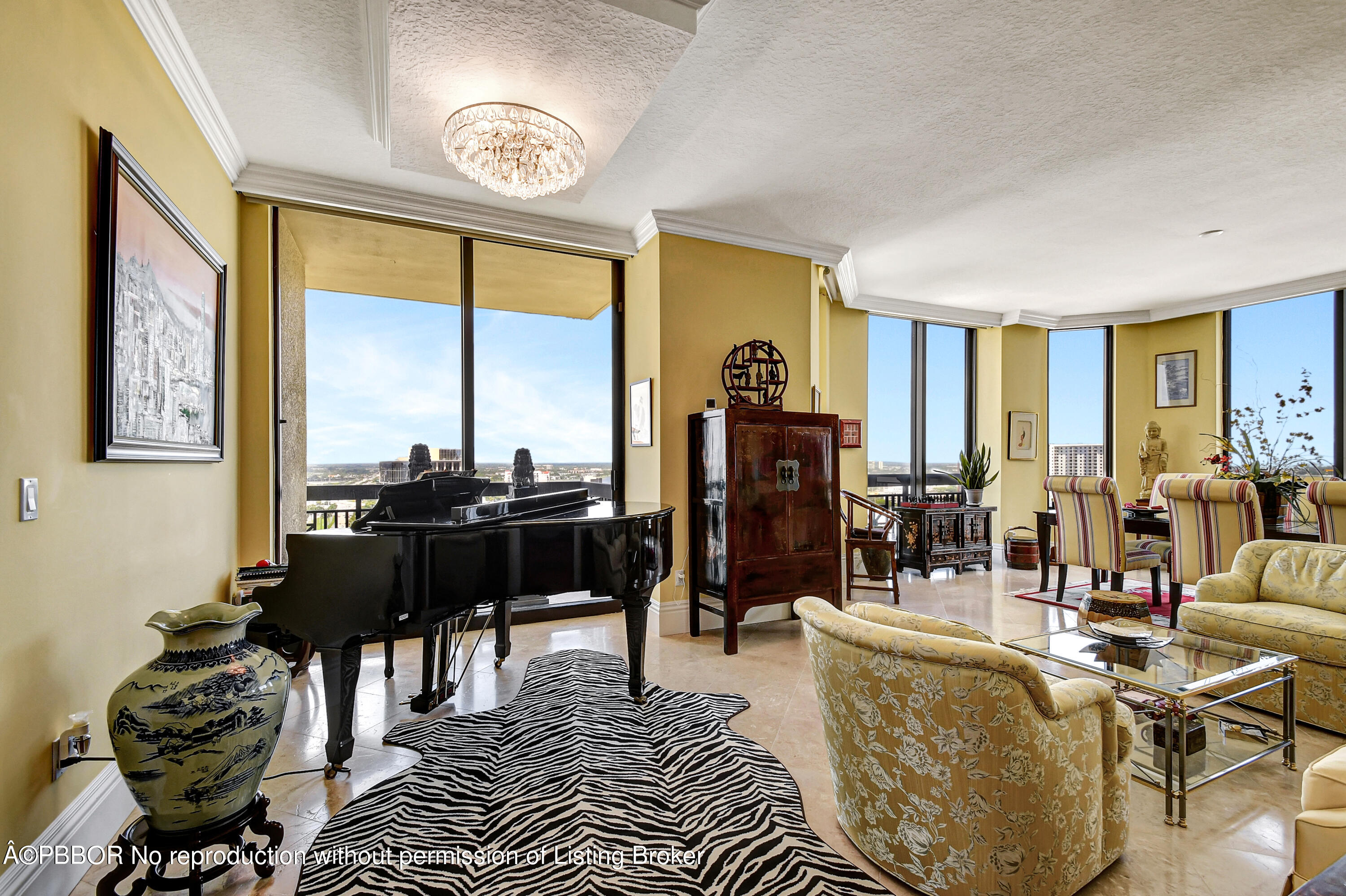 a living room with furniture a rug a large window and a chandelier