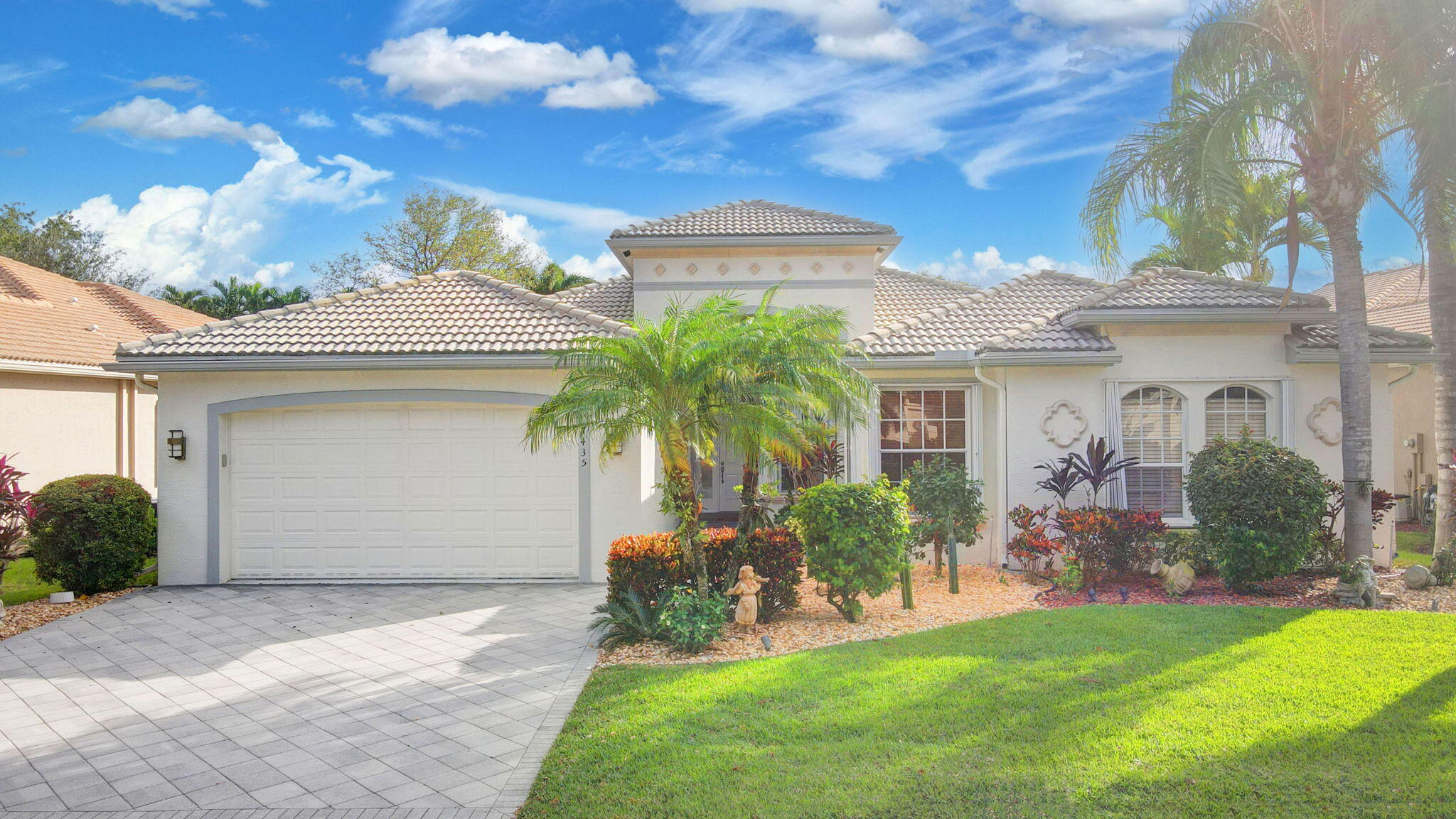 a front view of a house with a garden and plants