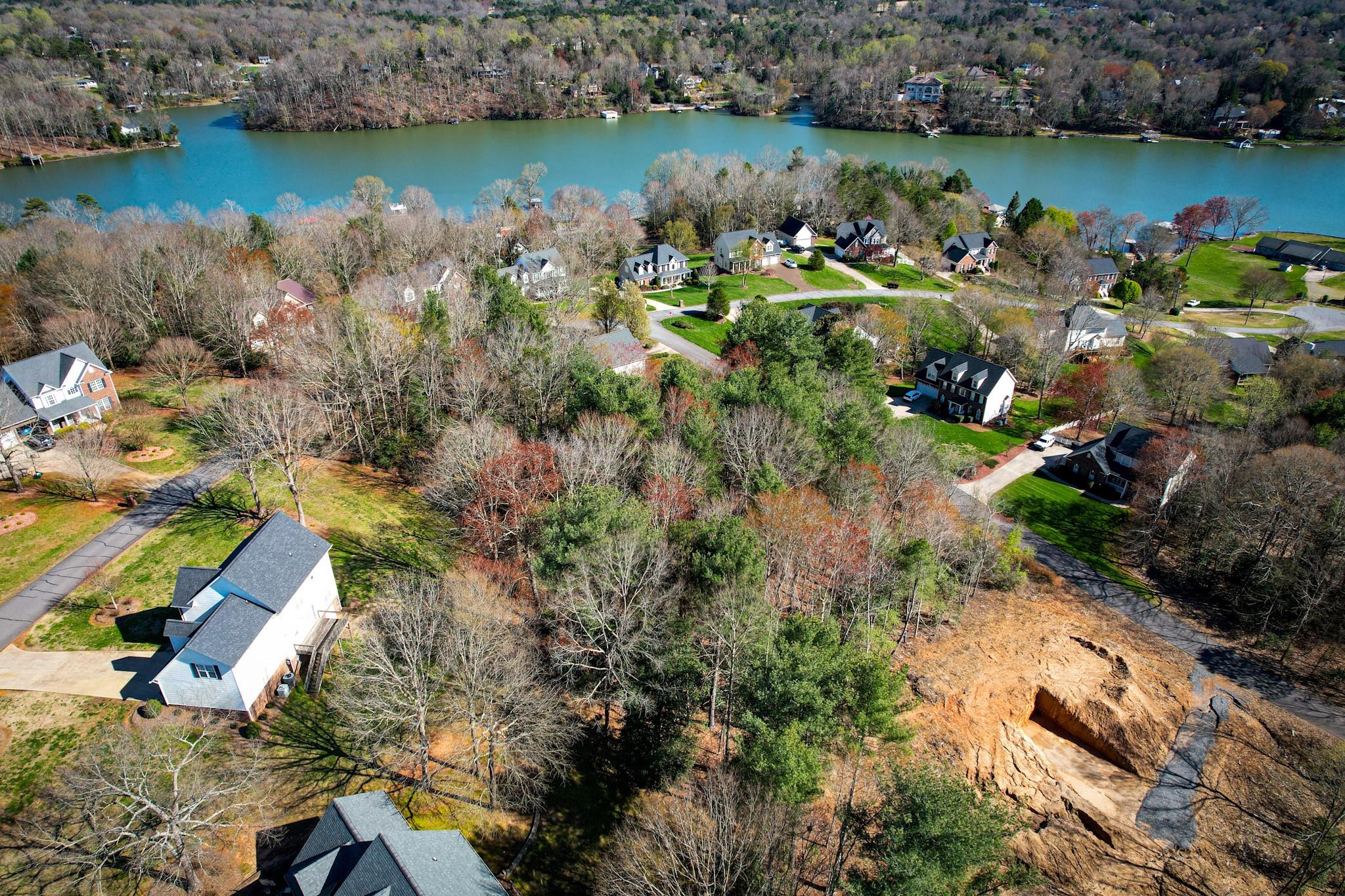 an aerial view of lake residential house with outdoor space and trees around