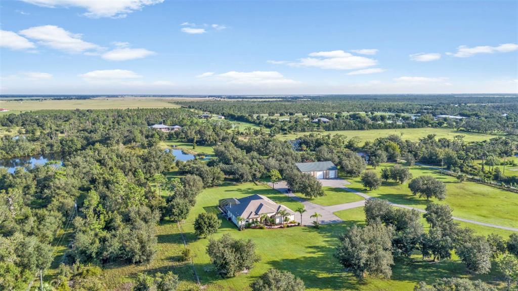 an aerial view of residential houses with outdoor space and lake view