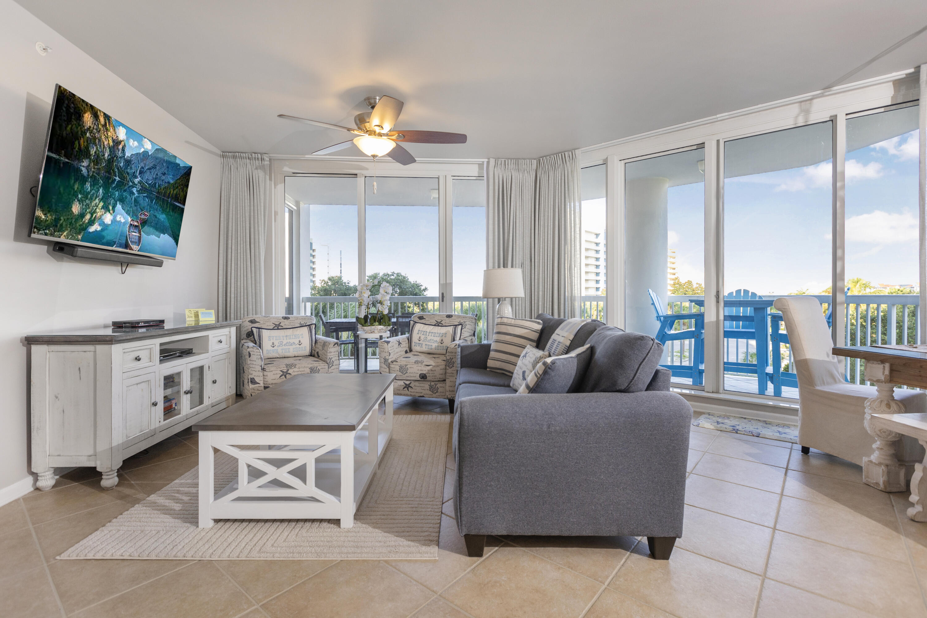 a living room with furniture a flat screen tv and a large window