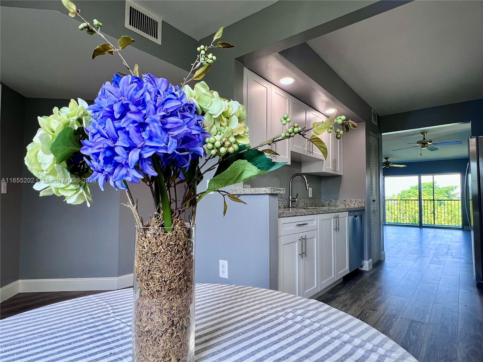 a vase of flowers sitting on a wooden floor