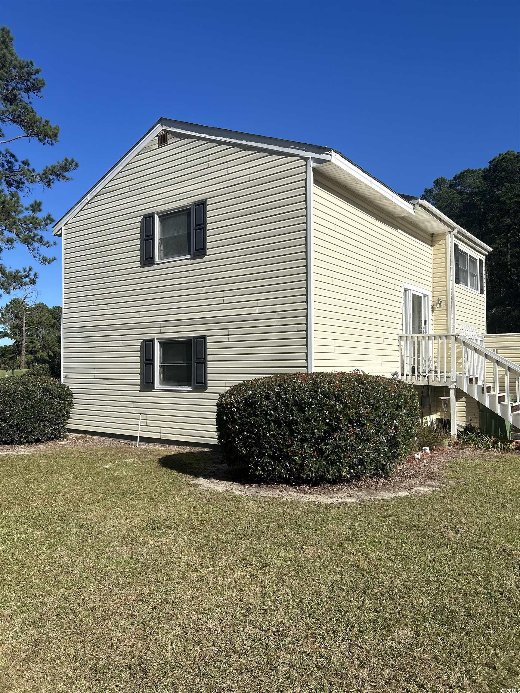 View of side of home featuring a lawn