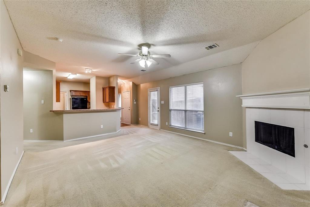 a view of an empty room with a fireplace and a window