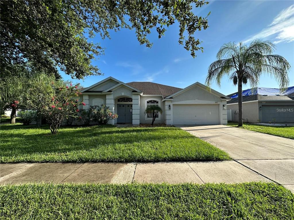 a front view of a house with a garden and trees