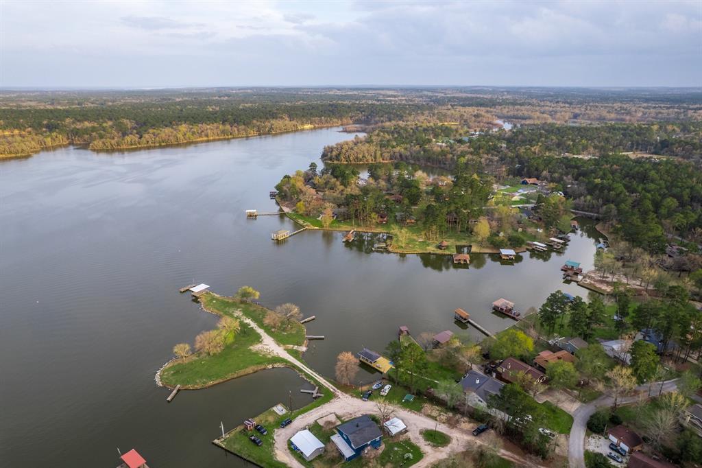 an aerial view of ocean and residential houses with outdoor space