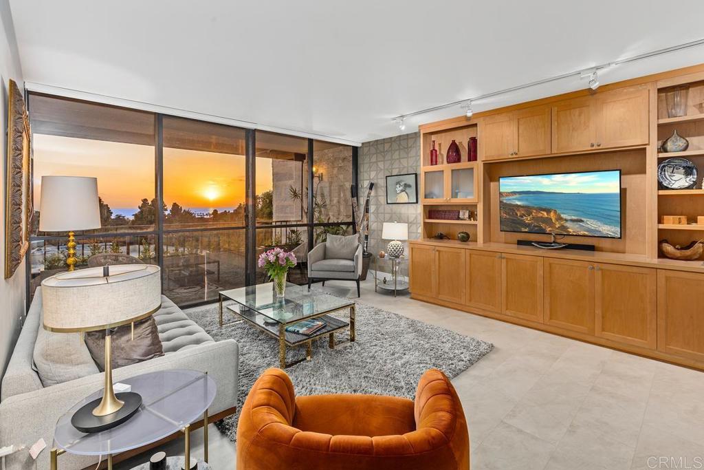 a living room with furniture and a floor to ceiling window