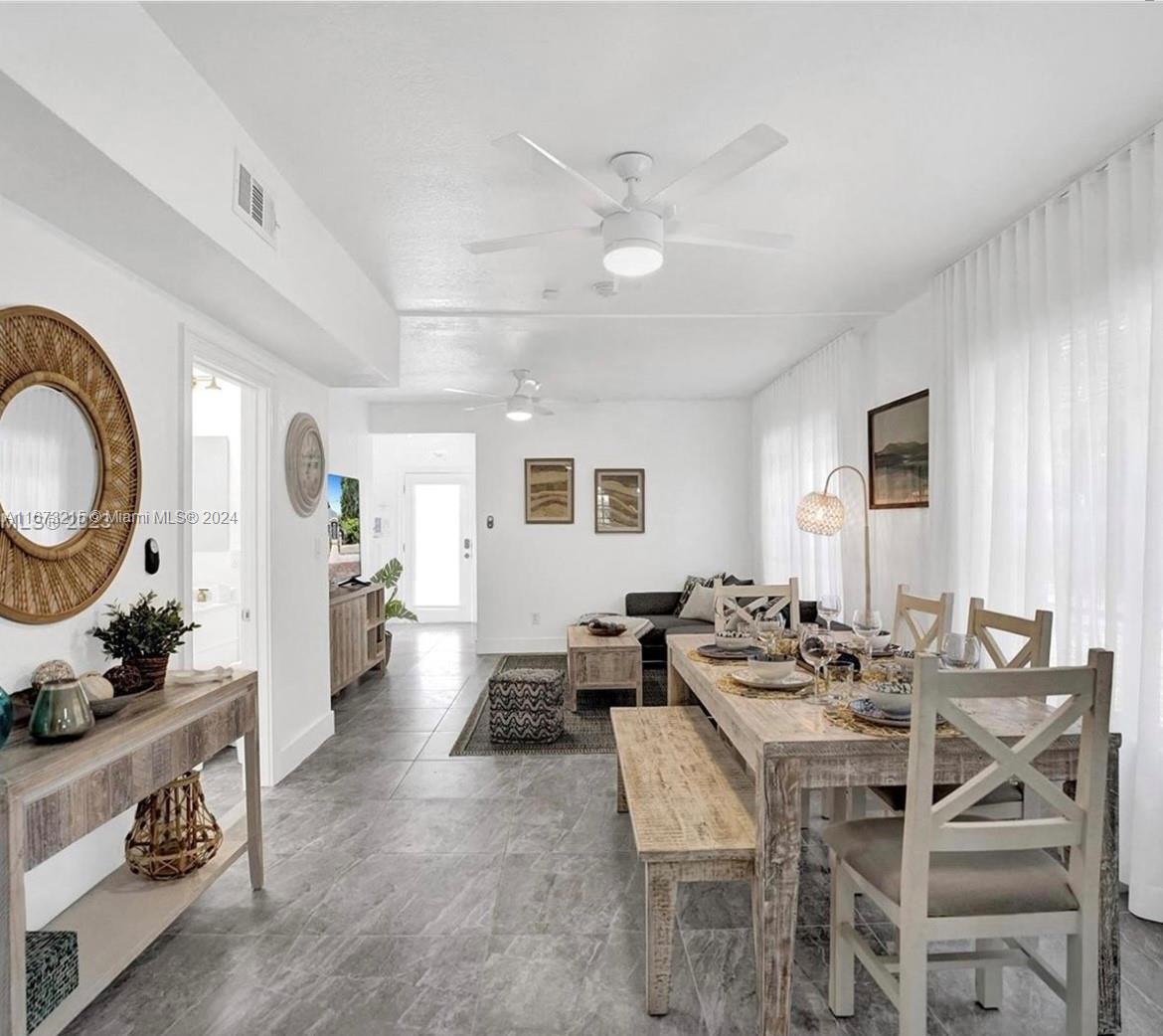 a dining room with wooden floor and a chandelier