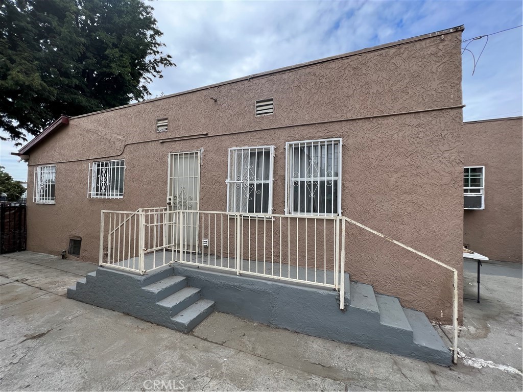 a view of a house with stairs and wooden fence