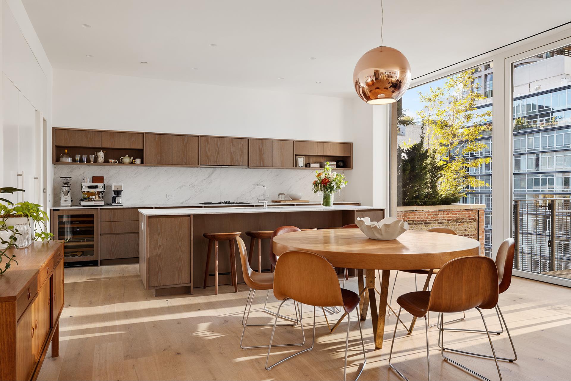 a kitchen with kitchen island stainless steel appliances a table and chairs in it