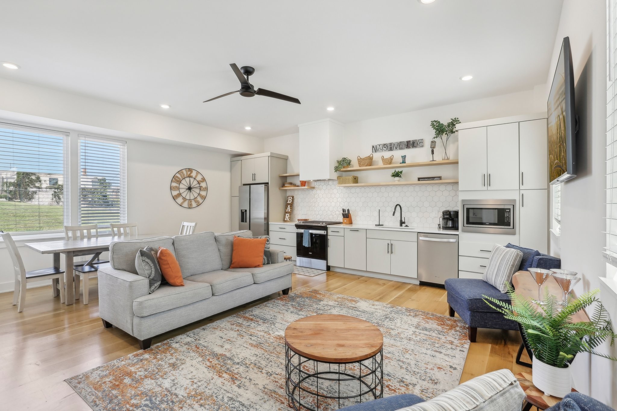 a living room with stainless steel appliances furniture and a view of kitchen